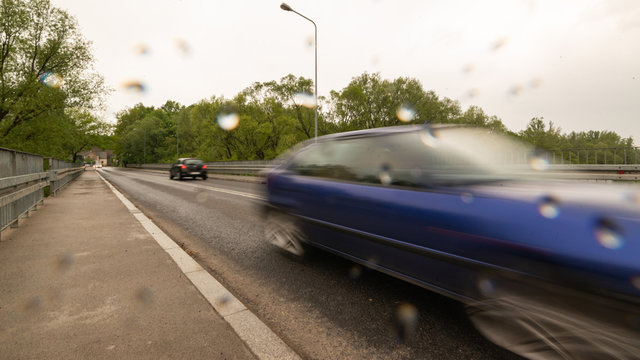 Rozmyte auto na moście w czasie deszczu 