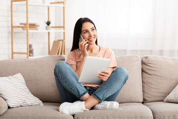 Woman talking on mobile phone sitting on couch