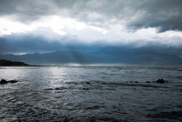 dramatic sky over mountains, rays of sun breaking through 