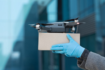 Drone delivering parcel to woman, contactless delivery