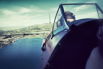 View back from cockpit of biplane flying over lake Wanaka, New Zealand