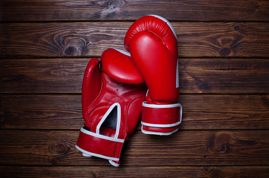 Red boxing gloves on wooden background