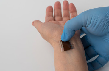 microchip is connected to a man hand. implantation of a chip under the human skin.