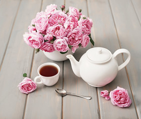Tea with pink roses on grey wooden table, copy spase. Greeting card for mother's day. Valentine card.Valentine Romantic Breakfast February 14. Women's Day.Happy Birthday! Wedding invitation