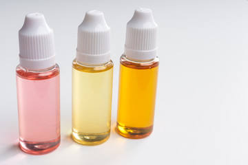 three e cigarettes liquid bottles on white background
