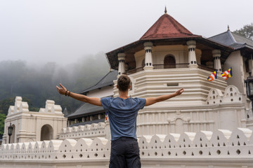 The young man observe Sri Dalada Maligawa temple in Kandy, Sri Lanka