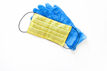 Yellow medical mask and blue gloves to protect health from the virus on a white isolated background