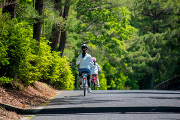 夏の公園で自転車を乗っている子供姉妹