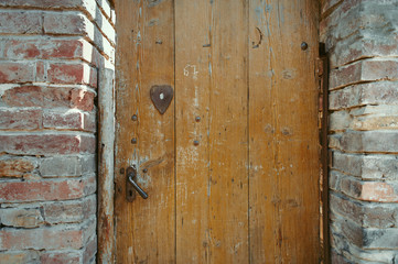 Ancient wooden door in old stone castle wall.