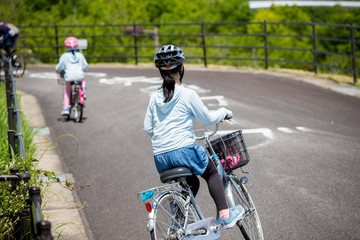 夏の公園で自転車を乗っている子供姉妹