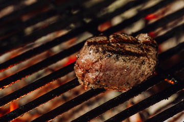 Tasty grilled beef steak with fire on the background