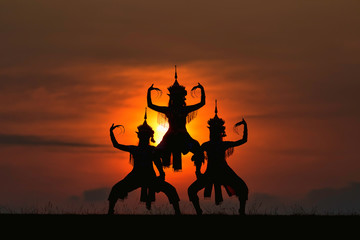 The black silhouette of three Manohra actors dancing in the park in the evening. Manohra performance is a folk dance that has a long history in southern Thailand.