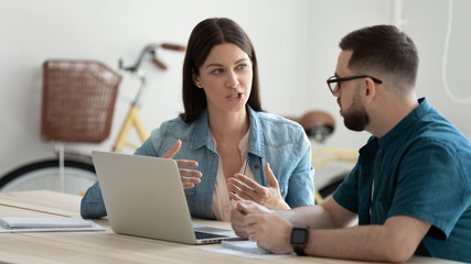 Confident woman and businessman talking in coworking office boardroom at meeting. Businesswoman...