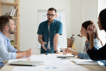 Confident bearded businessman with glasses presentation new project in coworking boardroom at...