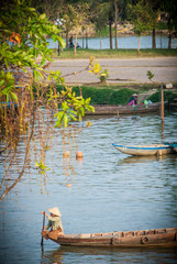 Vietnamese river boat with trees in the foreground