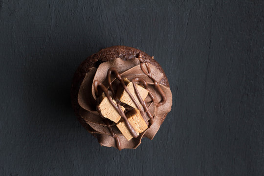 Top View Chocolate Cup Cake Isolated On Rustic Black Background - Overhead Photo With Space For Text