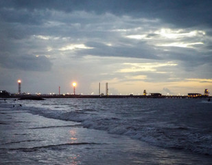 an oil refinery in a distance with sunset