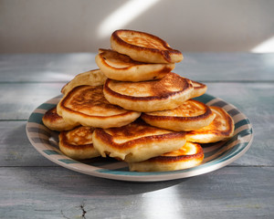 Obraz na płótnie Canvas Homemade pancakes laid out in a high slide on a striped plate