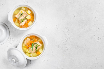 two ceramic pots  of  fish soup. Top view, copy space.