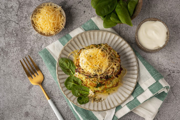 zucchini and spinach pancakes with cheese and sour cream, top view