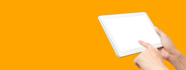 Hand holding tablet computer and touching blank screen on colorful orange banner background,...