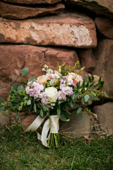 Fototapeta na wymiar wedding bouquet with roses leaning against red rocks outside