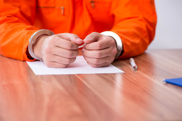Young man writing letter in provisional detention