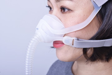 Close-up shot of woman wearing ventilator mask in ICU during new coronary pneumonia outbreak