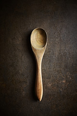 Rustic wooden spoon on rusty background. Culinary concept. Flat lay