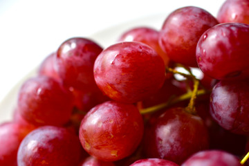 Bunch of red and large grapes on a white background