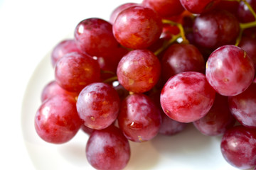 Bunch of red and large grapes on a white background