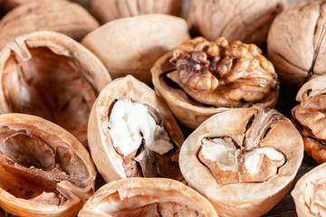 Close-up healthy chopped and unshelled walnuts on a wooden old table. Vegetarian food