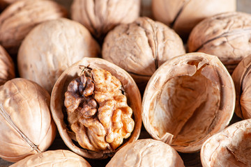 Close-up healthy chopped and unshelled walnuts on a wooden old table. Vegetarian food