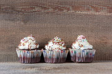 Delicious homemade cupcakes on a wooden table and background. Holiday food