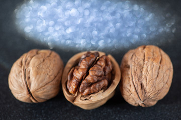 Three tasty walnuts with beautiful bokeh in the black background.