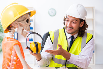 Funny construction business meeting with boss and skeletons