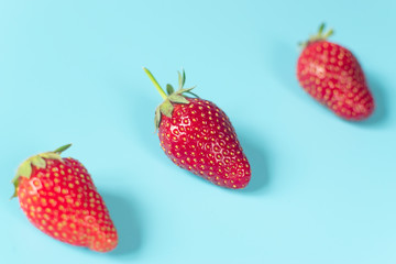 Fresh, red strawberries on light blue background