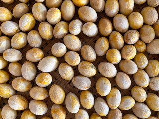 close up of pumpkin seeds. Legumes seeds in top view. White yellow seeds on bamboo background. Thai sweet vegetable.