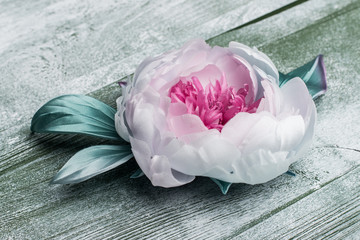 Pink artificial peonies on green wood table