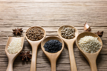 Variety of Thai and Indian spices and natural herbs supplements health food in bowl and spoon on rustic table with copy space.