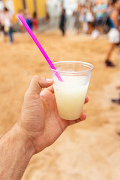 hand holds drink called pomada typical de menorca. With gin and lemonade (balearic islands, spain)