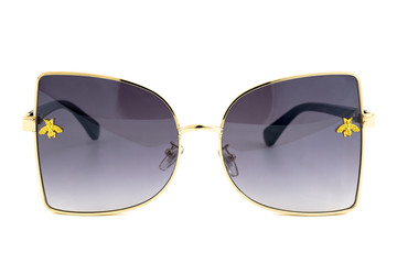 Butterfly rimless sunglasses with black gradient lenses and gold wrap around frames isolated on white background, front view.