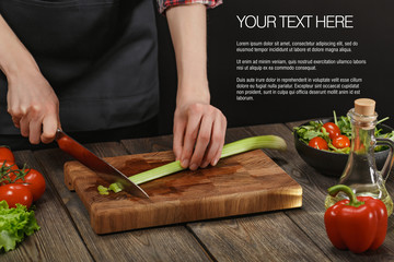 Woman cooking fresh healthy salad. Female hands cutting vegetables on board on wooden table with sample text.