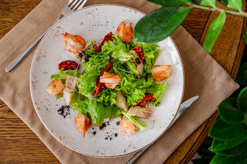 light healthy salad of fresh vegetables and shrimp. Photo in the interior