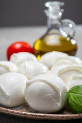 Tasty italian food, fresh white buffalo mozzarella soft cheese balls from Campania, tomatoes, fresh basil and olive oil
