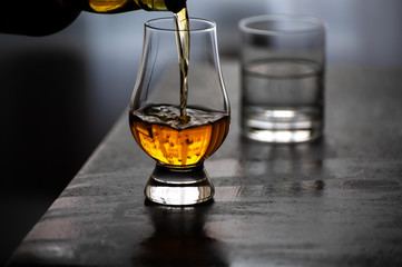 Pouring in tulip-shaped tasting glass Scotch single malt or blended whisky