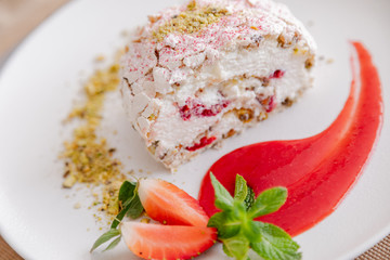 beautiful tasty green vegan dessert pistachio strawberry rolls on a wooden table in the interior.