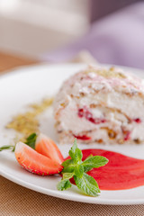 beautiful tasty green vegan dessert pistachio strawberry rolls on a wooden table in the interior.