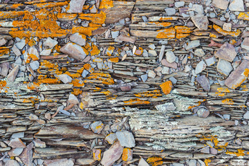 Detail of a wall with gray stone and orange lichen on the coast of Menorca (balearic islands, spain)