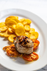 pork tenderloin in bacon on pepper with potatoes and tomatoes